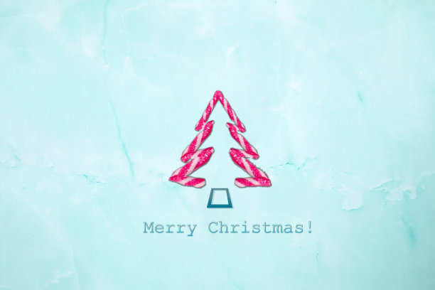 圣诞快乐的文字和形状的糖果拐杖圣诞树在浅蓝色的背景。新年冬季作文，假日，圣诞节，贺卡概念图片下载