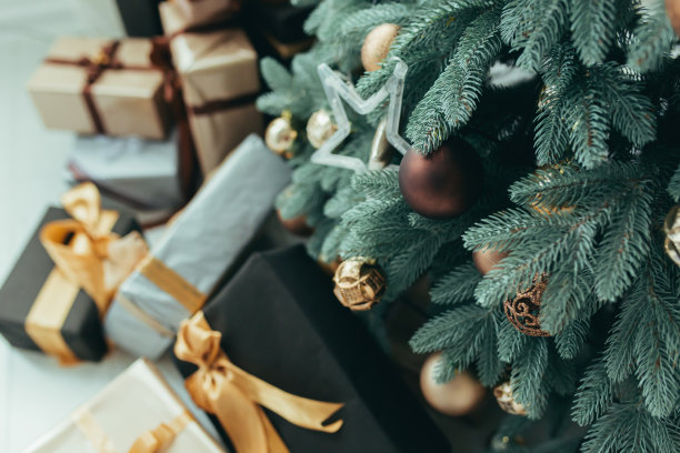 圣诞树下五颜六色的礼物照片除夕特写，五颜六色的礼物，红的、灰的和黑的图片下载