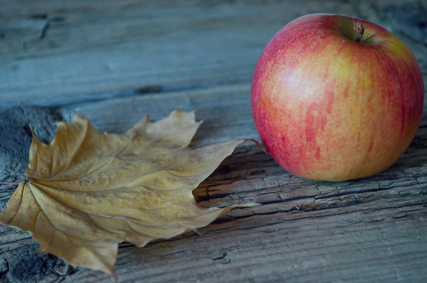 苹果和黄秋叶在老纹理木材背景图片下载