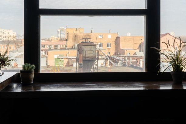 透过一家老式咖啡馆的窗户拍摄的一张废弃工厂的照片，里面有美味的咖啡图片下载