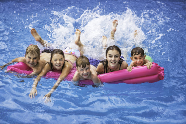 一群孩子在夏天的时候在游泳池里玩图片下载