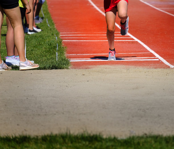 田径跳远比赛中运动员穿着红色短裤跑、跳图片下载