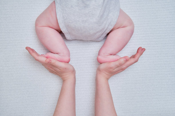 妈妈用女性的手教婴儿蹒跚学步的婴儿爬行图片下载