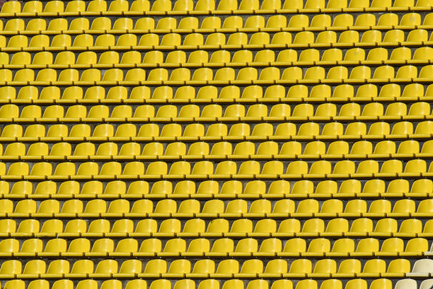 夏天的足球场上有很多排黄色的座位图片下载