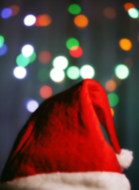 在散景背景上有一顶圣诞老人帽子的模糊图片。一个神奇的圣诞气氛。装饰的背景。节日的作文图片下载
