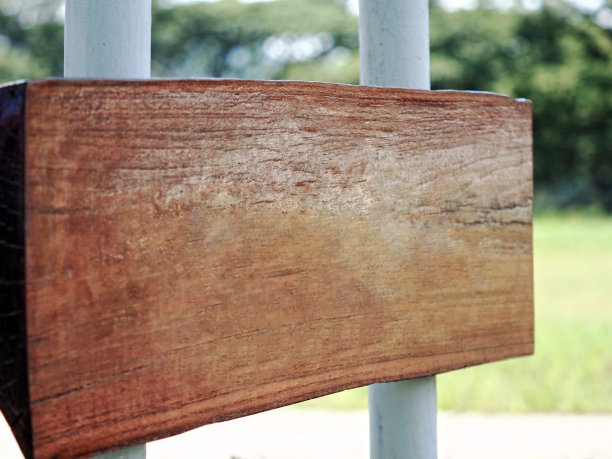 特写大的旧的粗糙的木制标签与绿色的散景图片下载