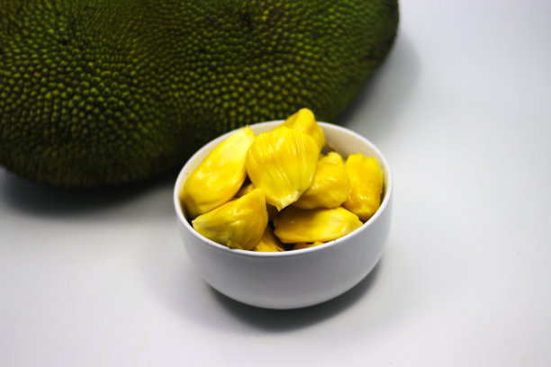 在白色背景上分离的白色碗上的新鲜成熟的插果(树果)。亚洲热带水果库存图片图片下载