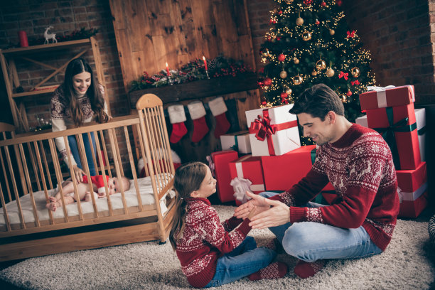 noel庆祝概念的照片，人们喜欢玩游戏，穿毛衣在装饰圣诞节的家室内图片下载
