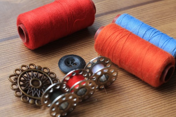 正在木桌上缝各种颜色的线图片下载