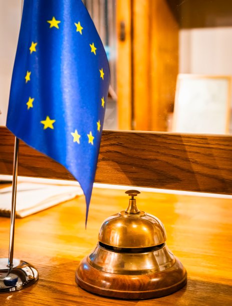 前台悬挂着欧盟旗帜和防护盾，以防疫情。接待业务立法和旅游行业。垂直背景空白。图片下载