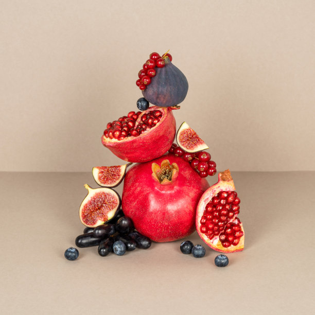 红石榴，无花果片，黑葡萄，蓝莓和醋栗在米色的背景。成熟多汁，营养均衡的秋季水果。秋天静物构图。美味的超级食物图片下载