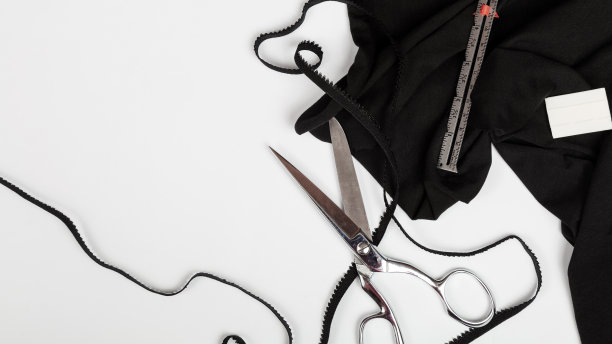 白色背景下的黑色棉织物。缝纫内衣。女性的时尚。缝纫的概念。服装生产用面料及辅料。横幅图片下载