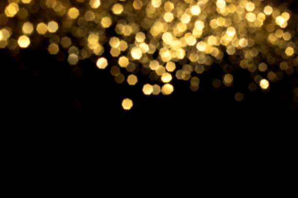 黑色背景上的金色模糊散景灯图片下载