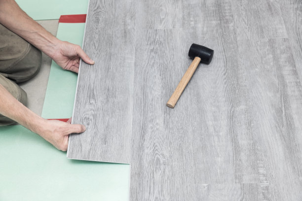 一个人在地板上放了一块石英层压板图片下载