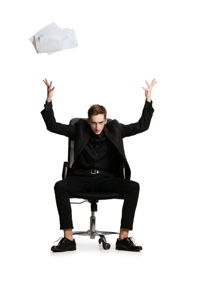 一名身穿黑色西装的年轻人，办公室经理坐在白色背景上的椅子上。艺术灵感的概念。图片下载