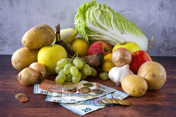 木桌上放着食物，还有欧洲的钞票和硬币。图片下载