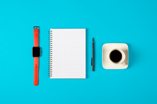 记事本，手表，笔和一杯咖啡被隔离在蓝色背景上。有复制空间的记事本。办公室，商务，低调的风格图片下载