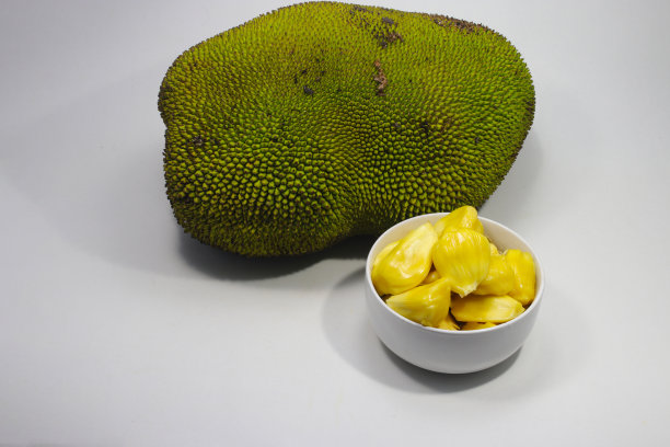 在白色背景上分离的白色碗上的新鲜成熟的插果(树果)。亚洲热带水果库存图片图片下载