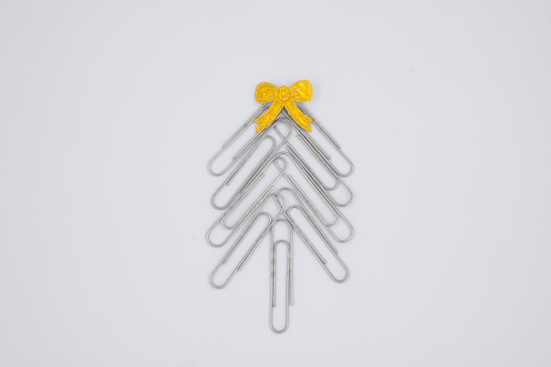 概念:办公室圣诞快乐。白色背景上的回形针做成的圣诞树。回形针圣诞树。圣诞节的背景。图片下载