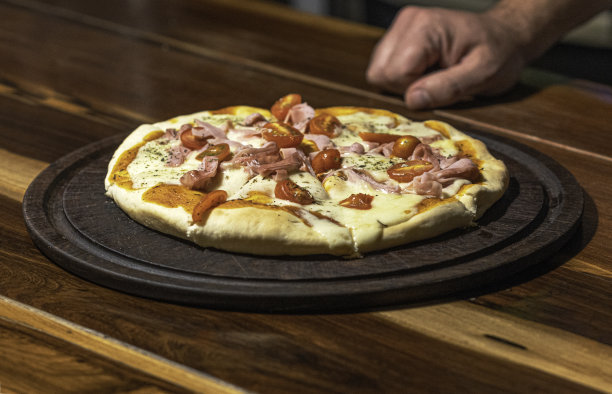 厨房桌上有自制的披萨，配上番茄和马苏里拉奶酪图片下载