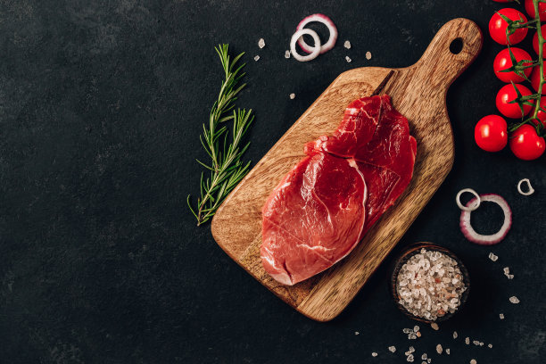 生牛排配迷迭香和辣椒，在深色的石头上图片下载