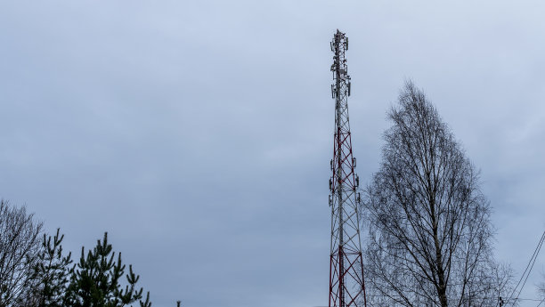 塔与移动运营商的天线在引人注目的天空背景。塔托管设备蜂窝。图片下载