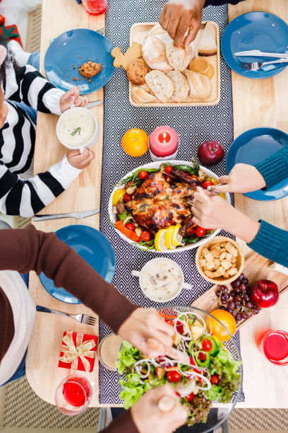 幸福家庭的俯视图正在家里吃晚饭。在圣诞树附近一起庆祝节日。非洲裔美国人家庭。图片下载