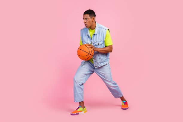 印象深刻的年轻男子的全长侧面照片打篮球穿t恤背心牛仔裤鞋子孤立的粉红色背景图片下载