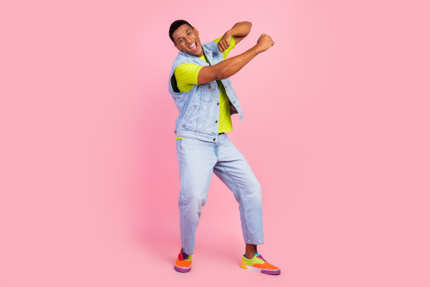 全尺寸照片的酷年轻的深色的家伙跳舞穿t恤背心牛仔裤运动鞋孤立的粉红色背景图片下载