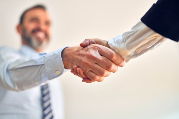 两名中年企业职员微笑着，快乐而自信。在办公室面带微笑地握手图片下载