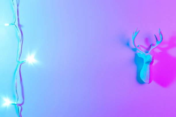 鹿灯霓虹圣诞冬季背景。最小抽象的圣诞驯鹿。假日装饰球霓虹灯梯度背景。最少的新年贺卡。图片下载