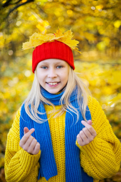 一个穿着黄色毛衣的金发美女的肖像图片下载