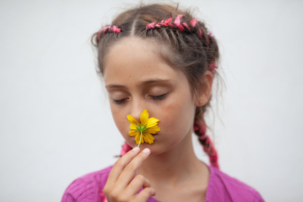小女孩闻着黄花图片下载