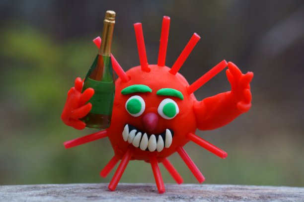 手上拿着一瓶香槟的病毒小雕像图片下载