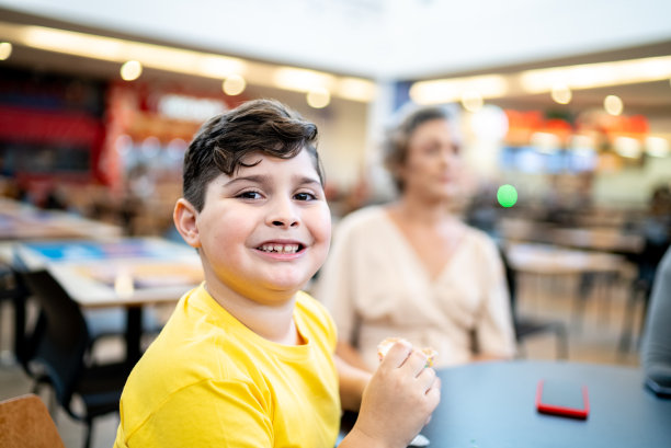 一个男孩在美食广场吃冰淇淋的照片图片下载