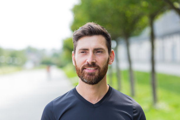 近景:年轻快乐的大胡子男子站在大自然的树林间放松，闭上眼睛呼吸新鲜空气。男宁静地享受着平静的生活，安静地在公园里。在户外。幸福图片下载