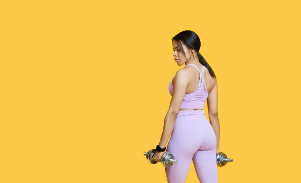 健身模式。非裔美国女士练习哑铃，在黄色背景，全景与复制空间图片下载