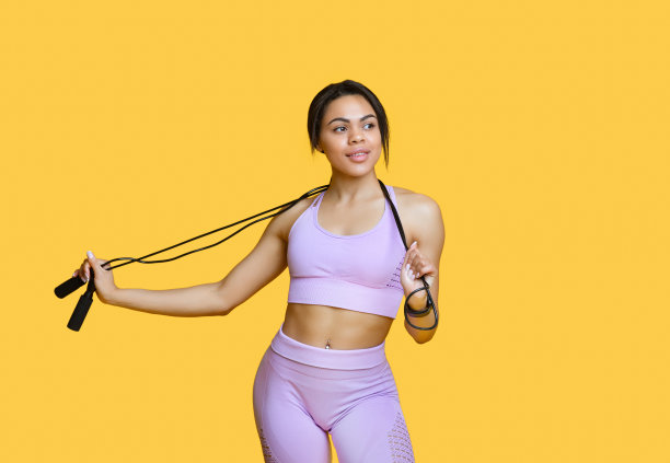 年轻的非洲裔美国女士手持跳绳的肖像，千禧一代的黑人妇女穿着运动服准备训练图片下载