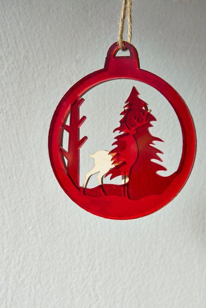 木制驯鹿与红色圣诞树装饰。图片下载
