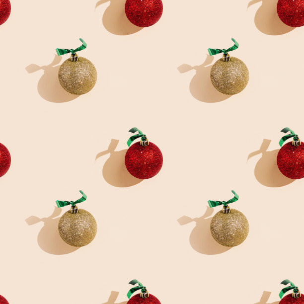 节日快乐，圣诞快乐，新年天衣无缝。闪亮的红色和金色圣诞球或圆形的小玩意与淡粉色阴影图片下载