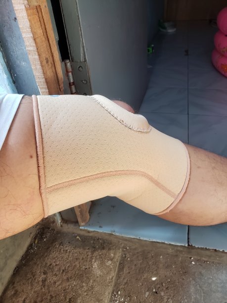 一名成年男子的左膝扭伤后戴着膝盖治疗支架图片下载