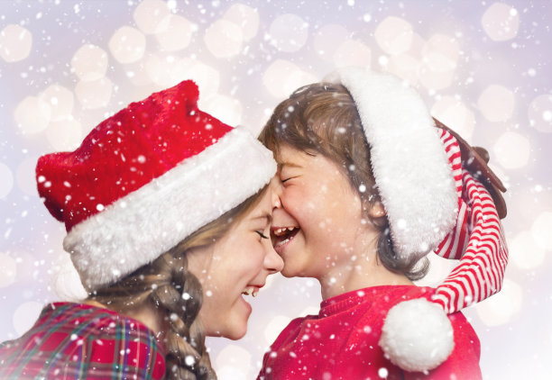 孩子们戴着红帽子在雪下笑图片下载