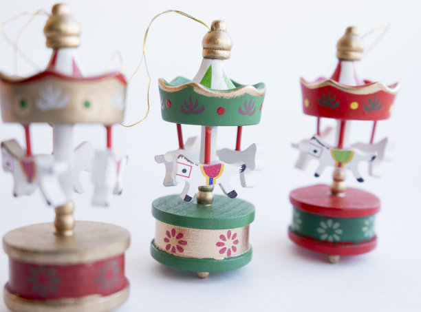 圣诞树上的木制圣诞玩具。圣诞节的环保玩具。一个小的红、绿、金的旋转木马，形状像一个帐篷，上面有白色的木马，由木头制成图片下载