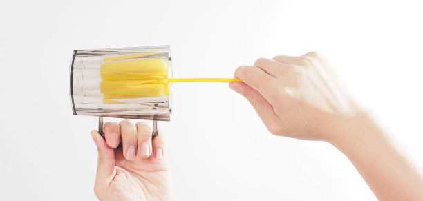 清洁和洗碗的概念。白色背景上的男子洗手酒杯。用柔软的黄色海绵棒清洗饮用玻璃。用海绵刷清洗杯子。新冠肺炎时代的消毒卫生图片下载