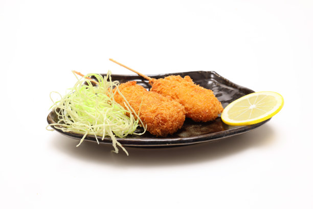 油炸的洋葱串和猪肉放在白色的背景上。图片下载