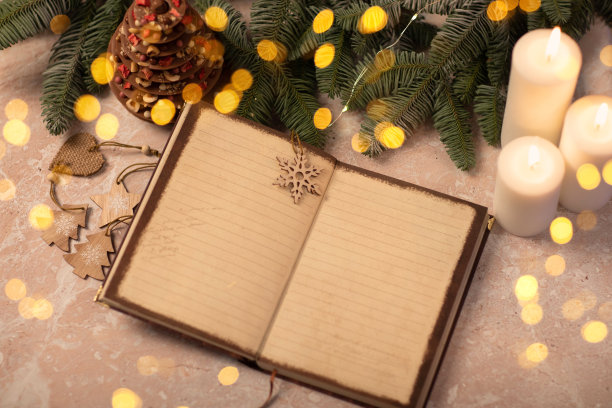记事本和圣诞灯饰，装饰。圣诞愿望清单、圣诞树、彩灯、蜡烛和米色背景上的笔记本。平铺，俯视图，复制空间，模拟文本图片下载