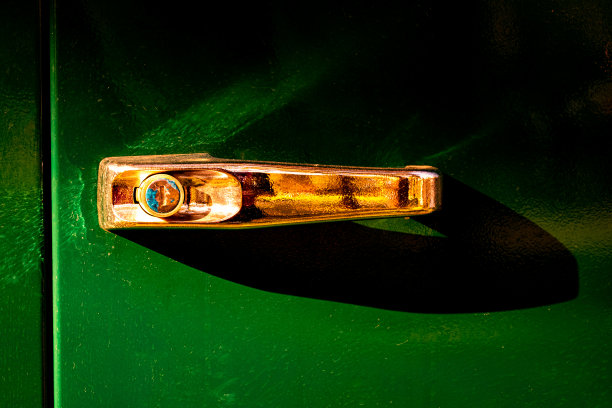 金色门把手隔离在绿色背景上图片下载