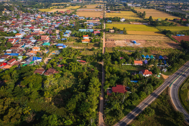 鸟瞰图的小农村城镇旁边的稻田在泰国农村图片下载