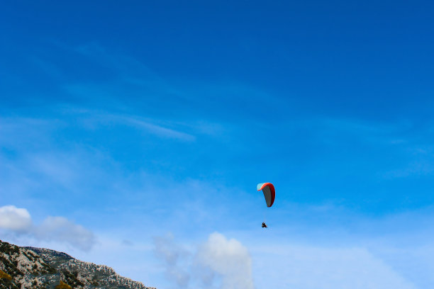 滑翔伞剪影飞行在朦胧的山谷在美丽的温暖的日落颜色-运动，活跃的壁纸充满了自由。图片下载