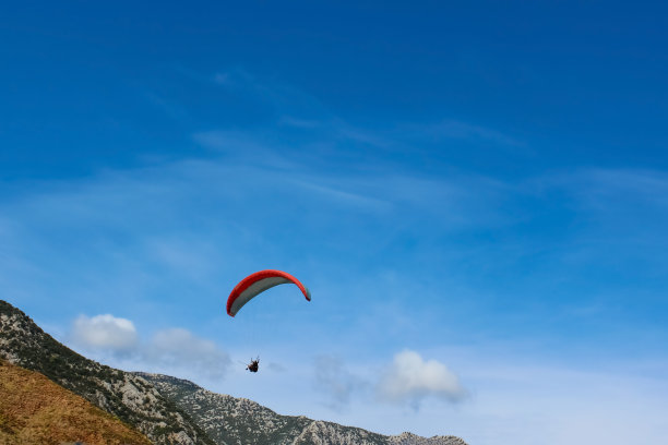 滑翔伞剪影飞行在朦胧的山谷在美丽的温暖的日落颜色-运动，活跃的壁纸充满了自由。图片下载